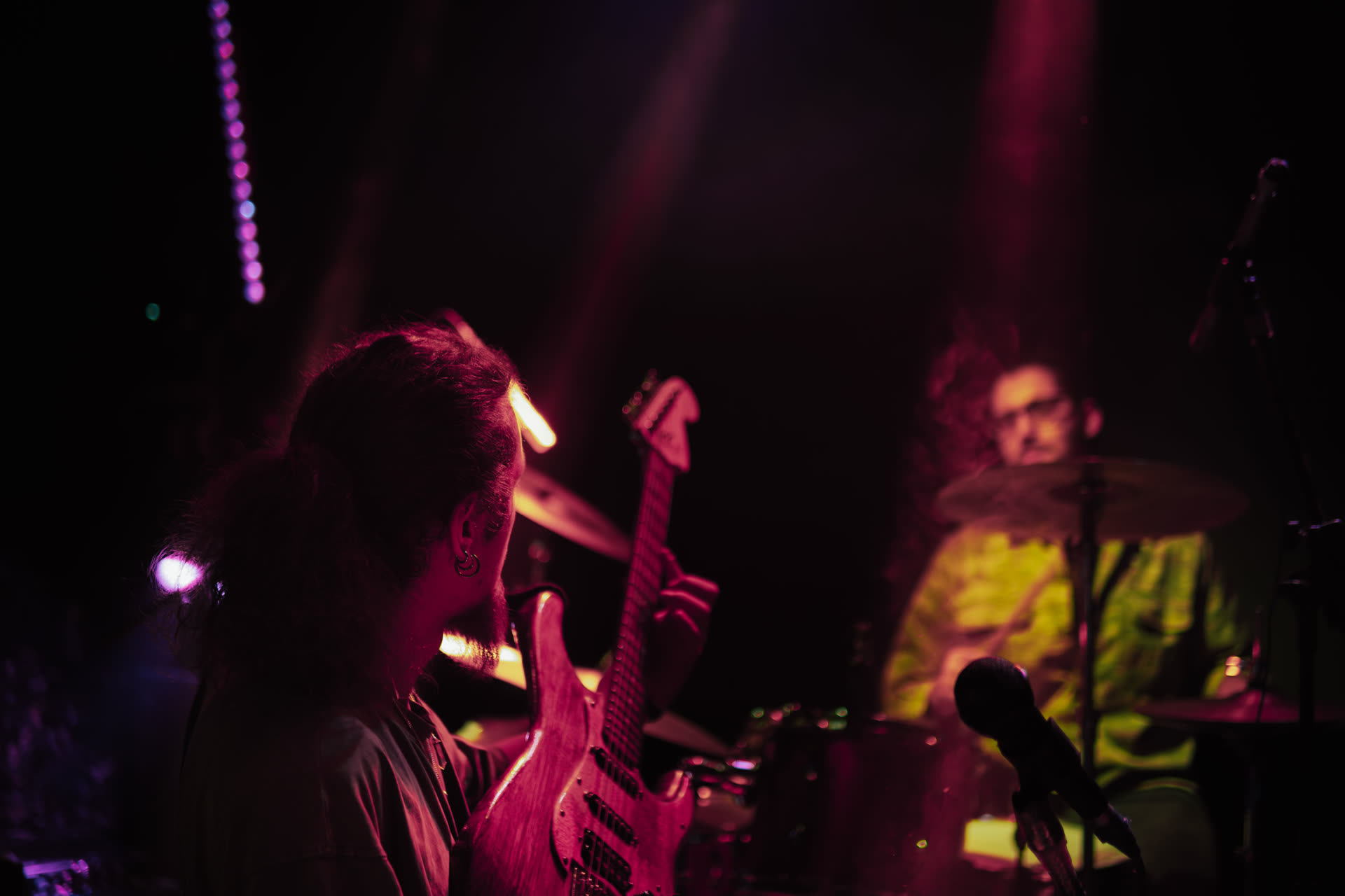 Guitarist with an orange PRS under stage lights
